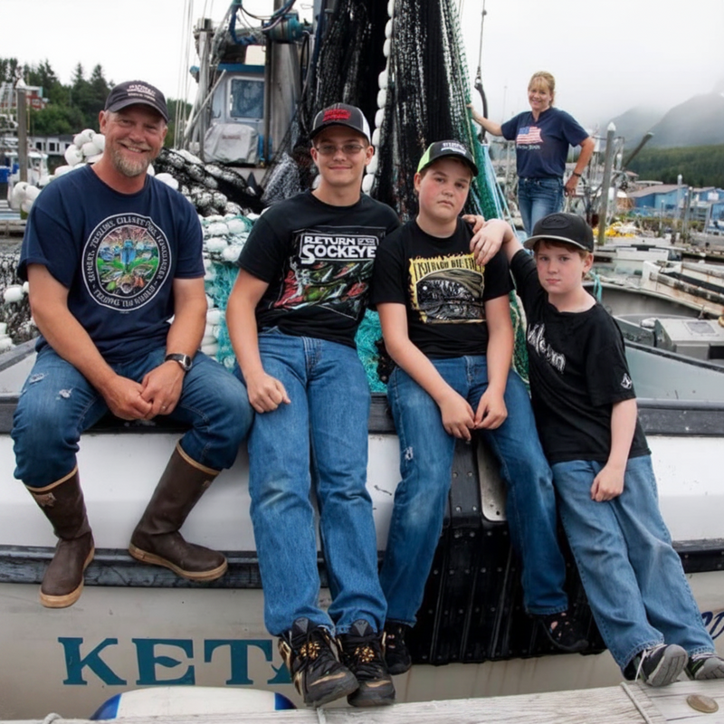 Parkers family on a boat with a scenic background in Alaska